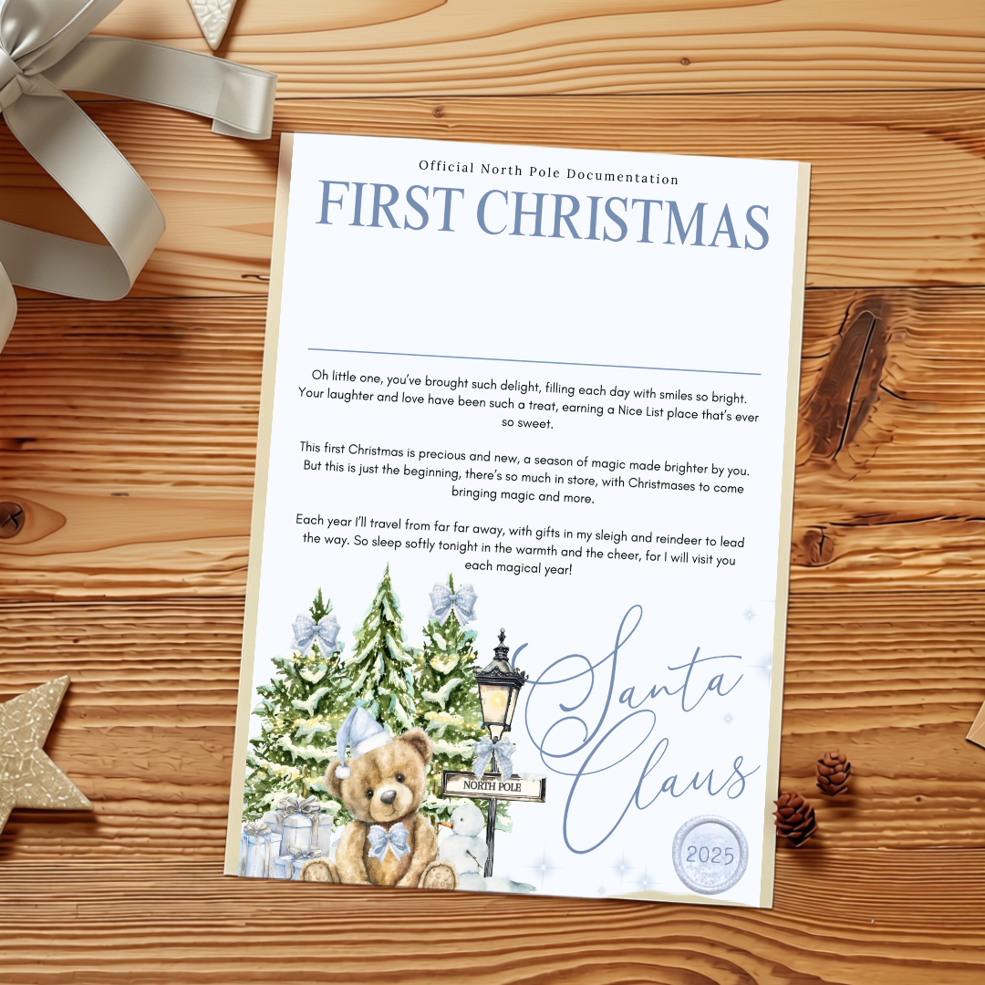 A printed personalized Christmas card titled 'FIRST CHRISTMAS' with a poem, illustrated with a Christmas tree, snow globe, and Santa Claus, photographed on a wooden tabletop with ribbon and star decorations.