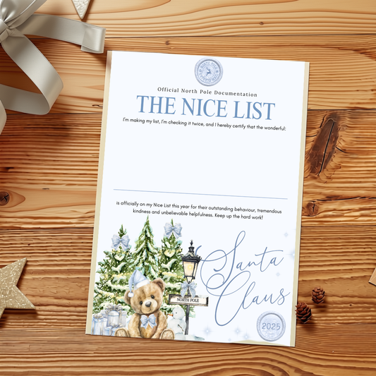 A printed holiday document titled "THE NICE LIST" with blue text and a Christmas tree illustration, photographed flat on a wooden surface with a ribbon, star, and pinecone nearby.